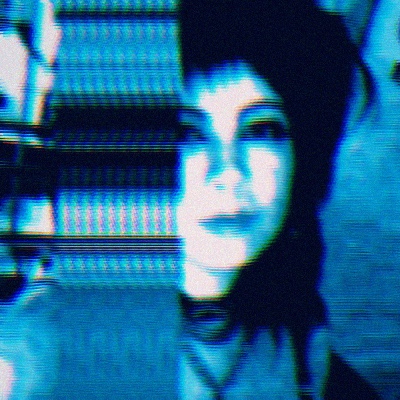 a glitchy picture of a smiling person with dark hair.