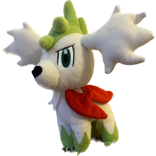 Shaymin, a Pokemon plushie who looks like a little green and white hedgehog, this plushie has them in their Sky Form, which gives them more of a canine appearance.